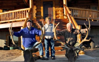 group posing with elk horns