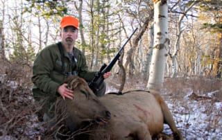 man posing with elk and horns