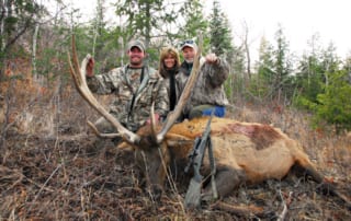 group posing with elk and horns