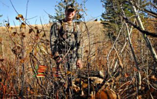 man posing with elk and horns