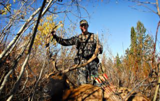 man posing with elk and horns