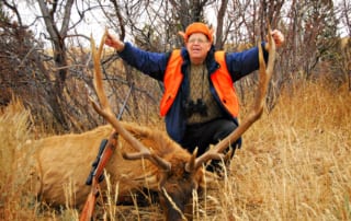 man posing with elk and horns