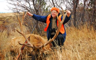 man posing with elk and horns