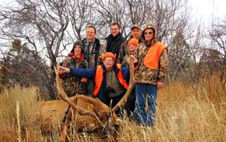 group posing with elk and horns