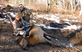 man and woman posing with elk