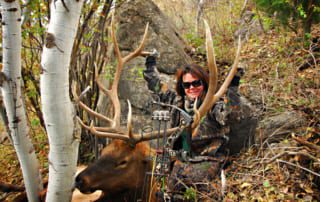 woman posing with elk and horns