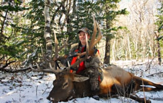 woman posing with elk and horns