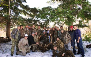 group posing with an elk and horns