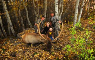 group posing with an elk and horns