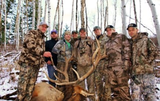 group posing with an elk and horns