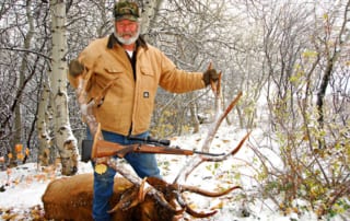 man posing with an elk and horns