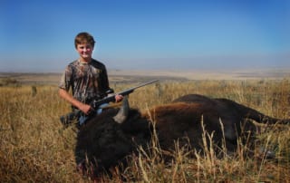 young man posing with a buffalo