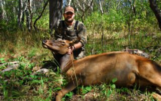 man posing with an elk