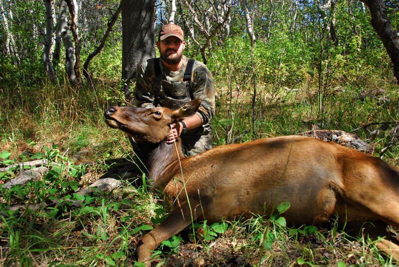 man posing with an elk