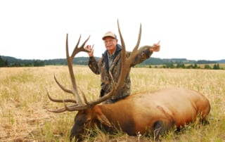 man posing with an elk and horns