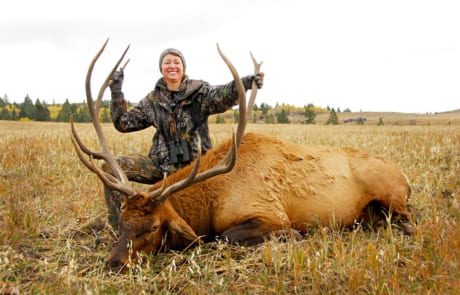 woman posing with an elk and horns