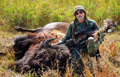 man posing with a buffalo