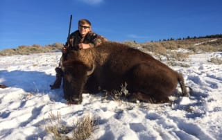 man posing with a buffalo