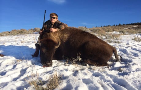 man posing with a buffalo