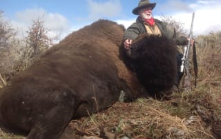 man posing with a buffalo