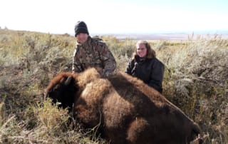 man and woman posing with a buffalo