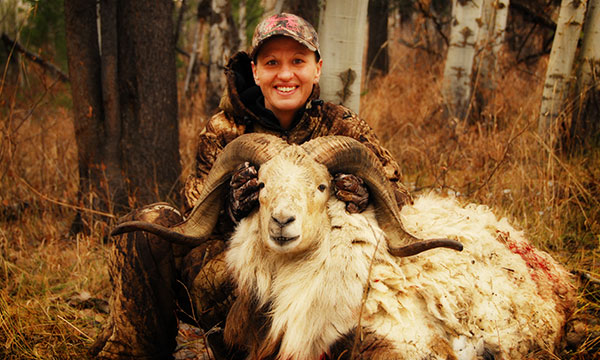 hunter posing with sheep with large horns