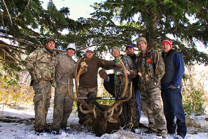 group posing with elk and horns