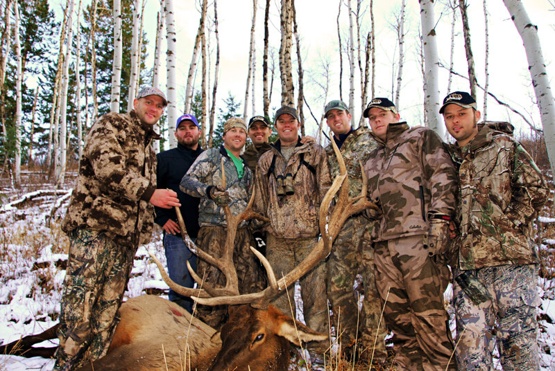 group in camoflage with large elk