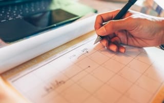 A busy hand scrawls across a calendar counting the days until a guided elk hunt in Idaho.